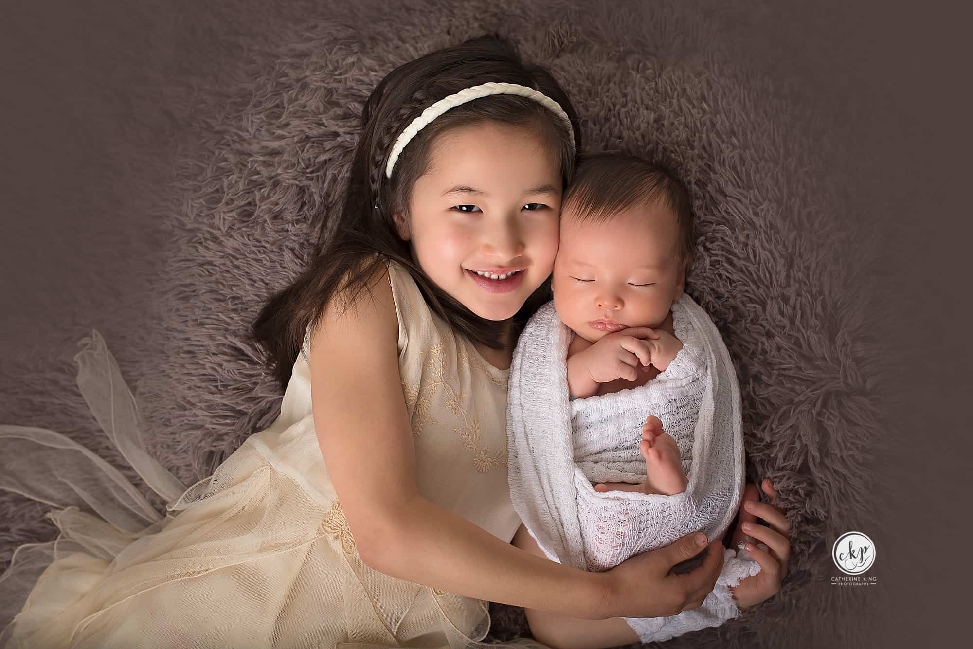 4 week old James and his sister during a newborn photography session