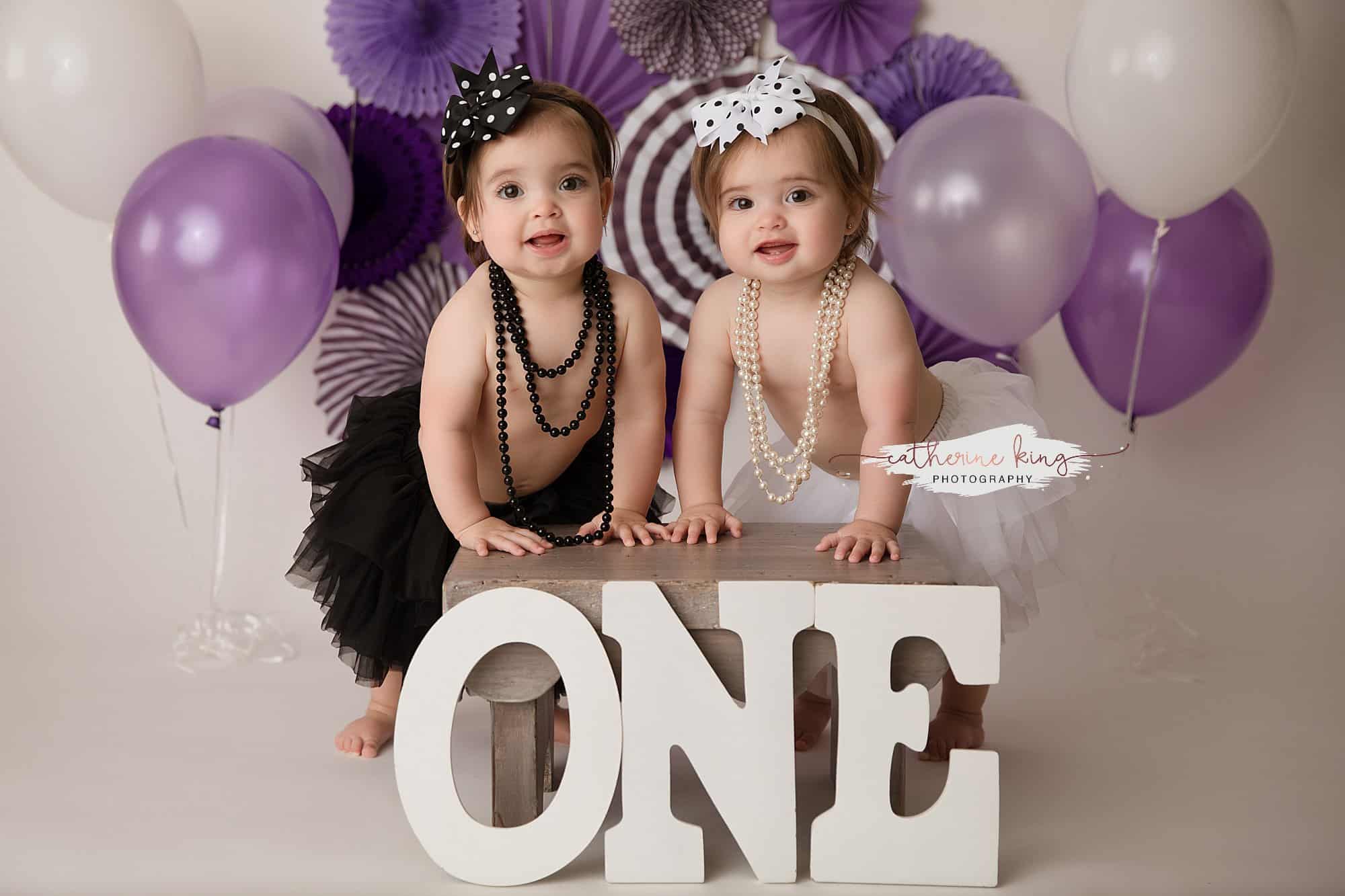 twin girls in front of ONE sign